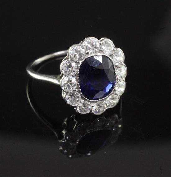 A white metal, sapphire and diamond oval cluster ring size M.